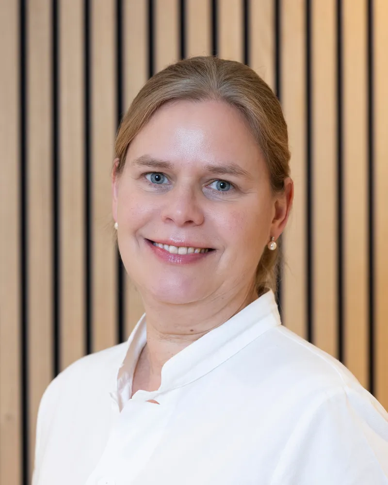 Porträt von Dr. med. Swantje Eggers vor heller Holzwand
