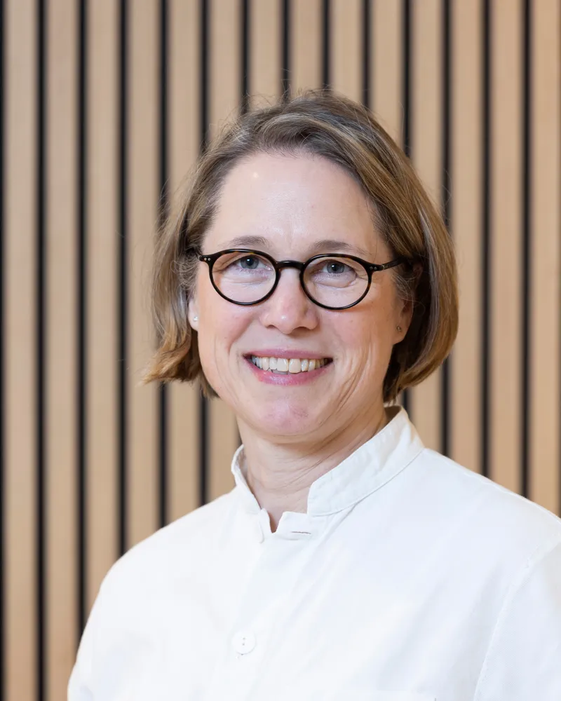 Porträt von Dr. med. Nadja Zingel vor heller Holzwand
